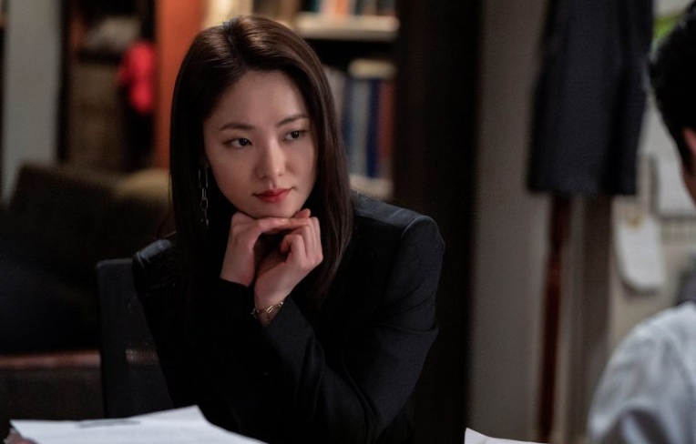 The main female lead from Vincenzo watching toward Vincenzo Cassano