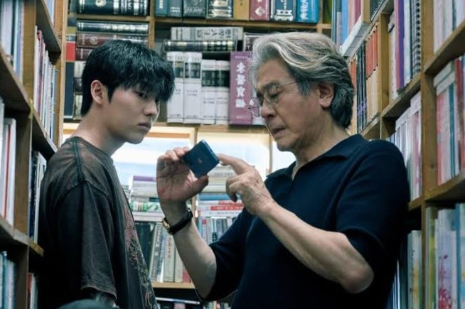 The professor showing something to a student in library in Notes from the Last Row