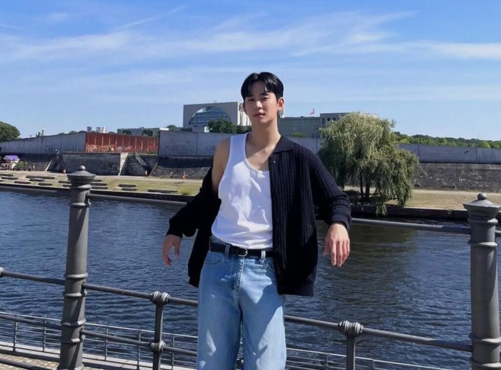 Kim Soo-hyun is standing with the grills of bridge on the upper side of water