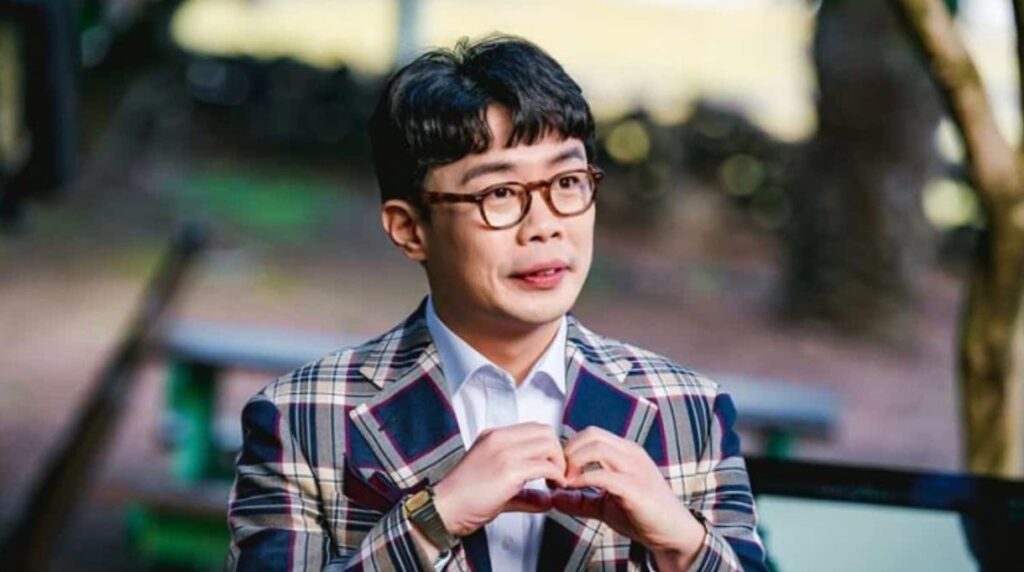 Noh Sang sik the character played by Ahn Se ha in King the Land is sitting on the bench and watching someone with smile