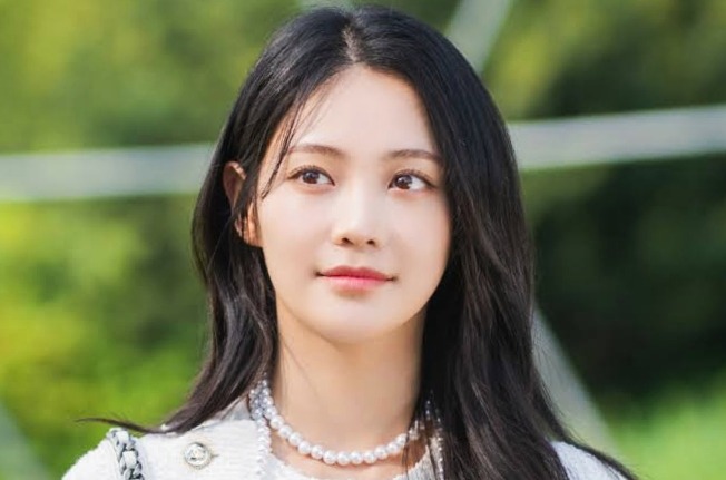 Woo Da bi as Ha-yeong in Dynamite Kiss and she is sitting and watching toward something with smile