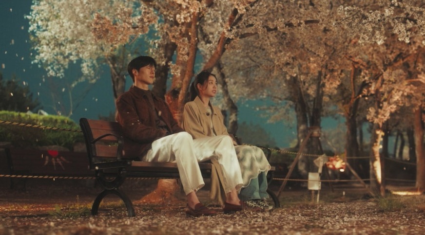 The charming scene of the main leads of Dynamite Kiss where both of them are sitting on the bench at night under the tree
