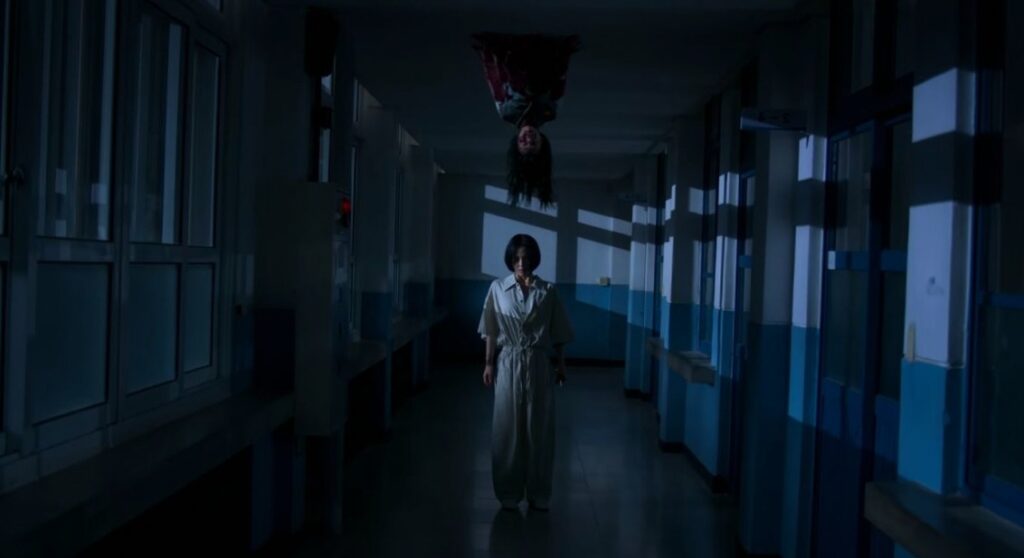 The scared image in which one girl is standing and on her their is ghost on the roof in If Wishes Could Kill